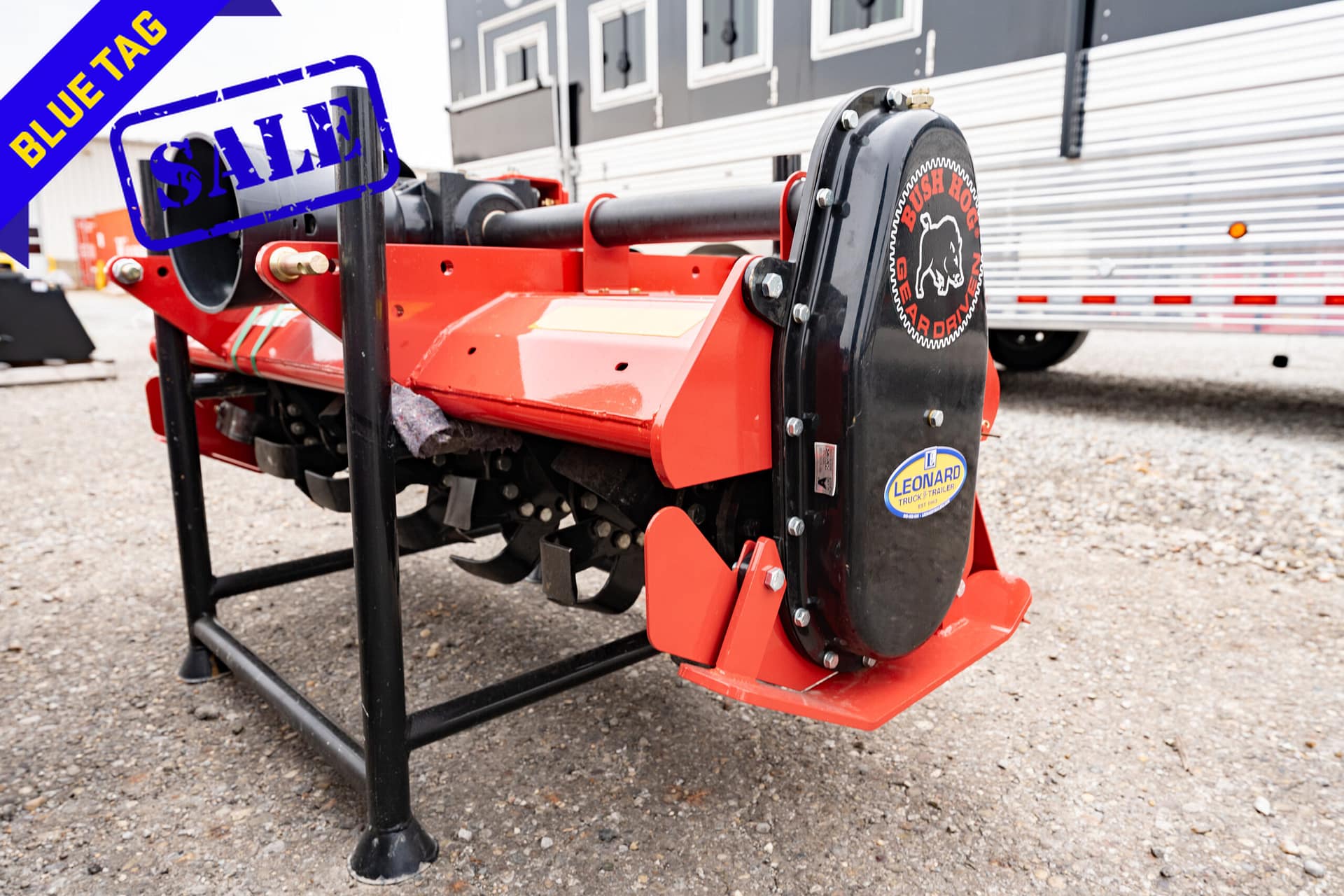 Red agricultural trailer hitch/frame on gravel, with a blue 'Blue Tag' sale banner and a large blue 'SALE' stamp overlaying the image.