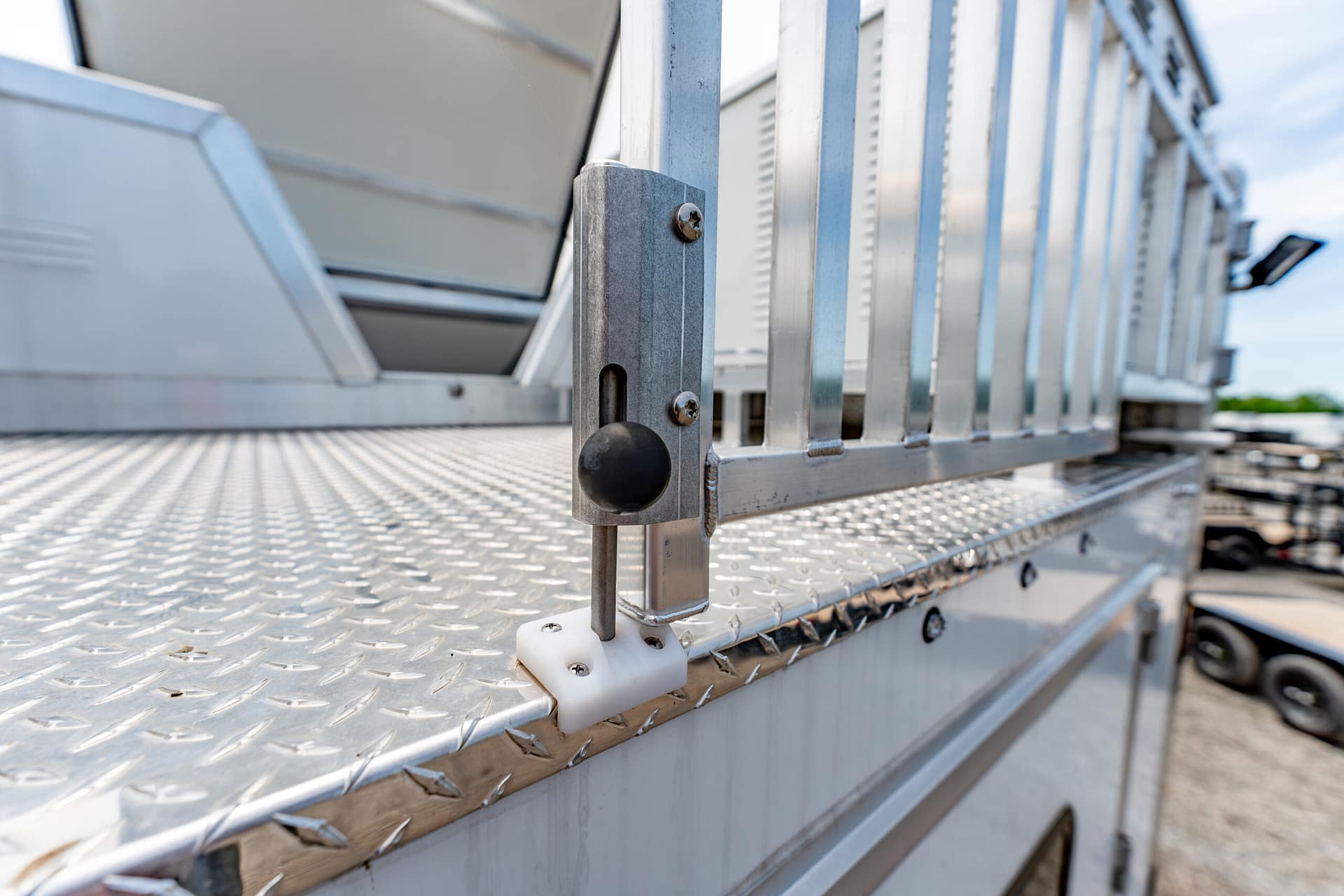 Close-up of a metal ladder railing and diamond-plate platform on an industrial vehicle used for service work.