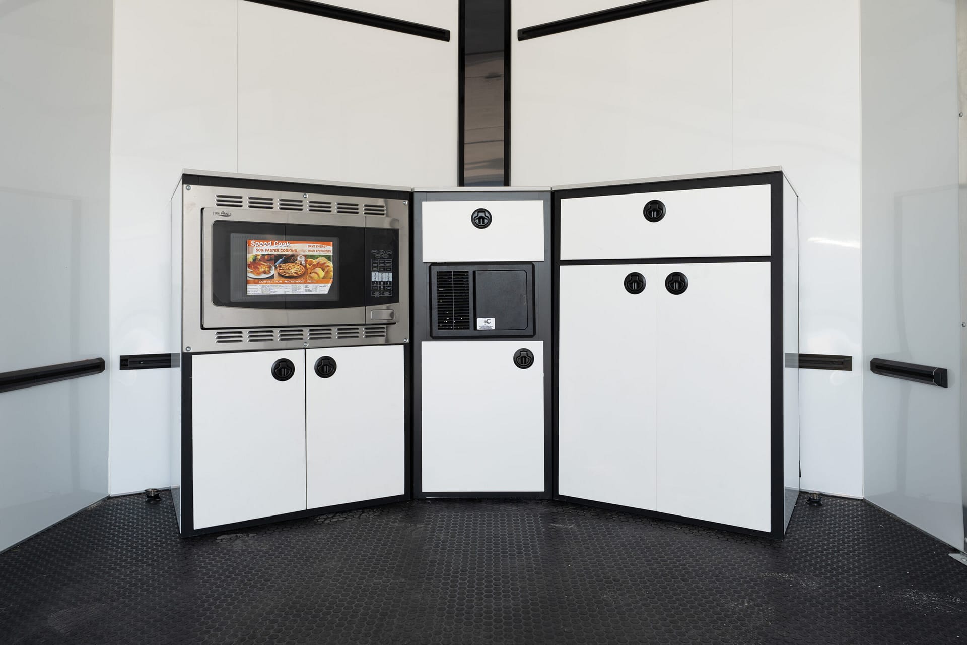 Modern built-in kitchen with white cabinets and a stainless steel microwave and oven in a corner display.