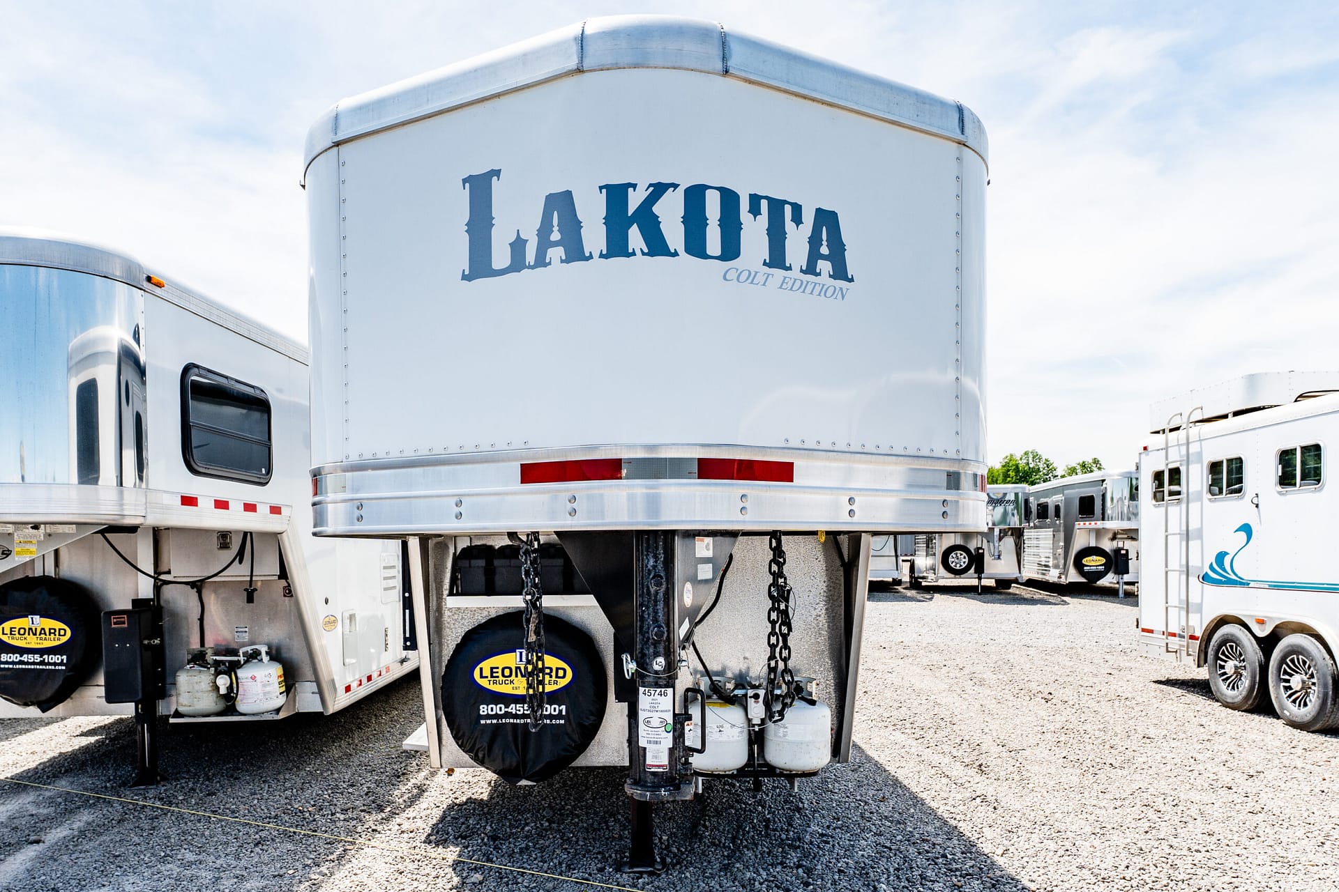 White Lakota Colt Edition horse trailer parked in a lot among other trailers, front view with branding visible on the nose.