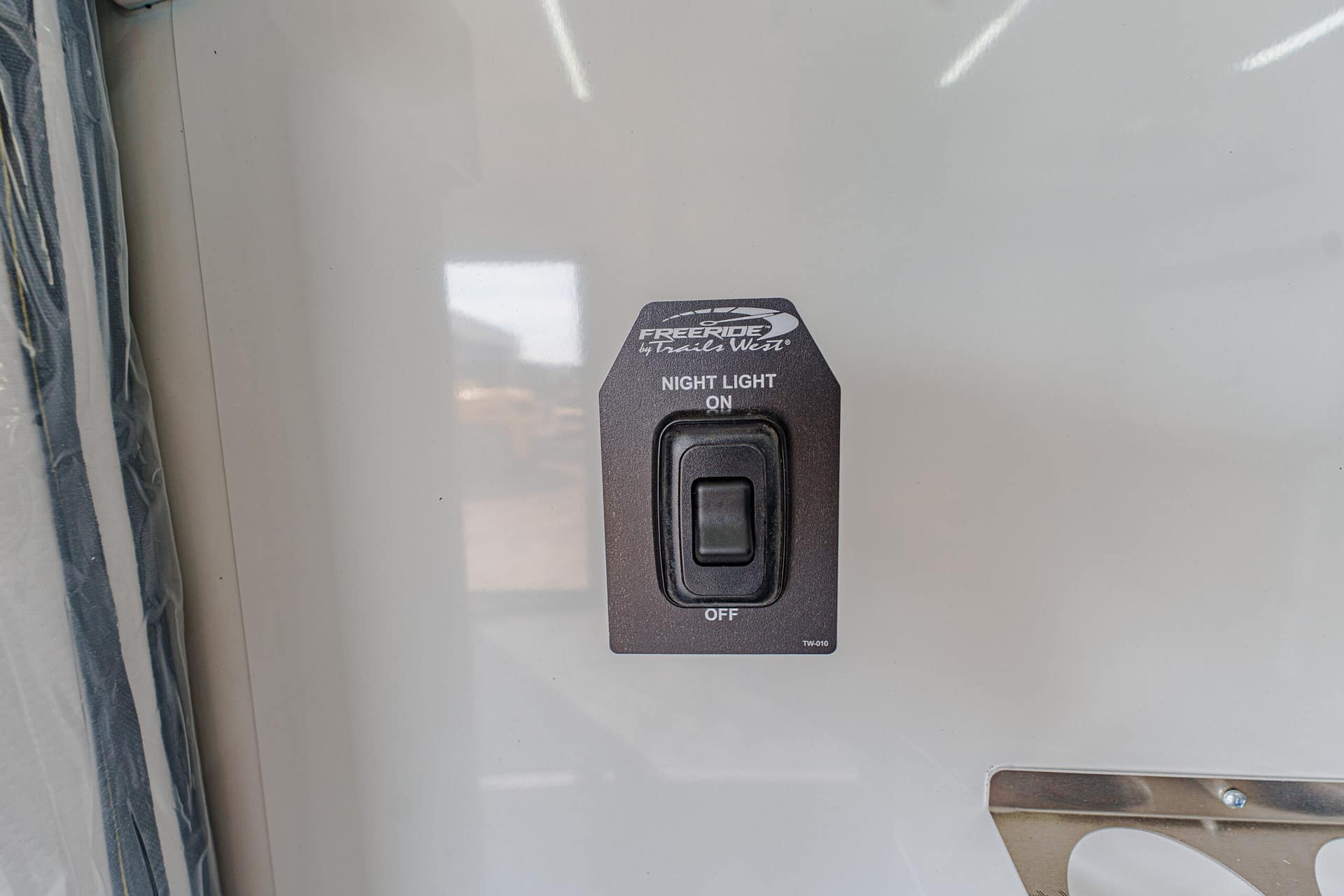 RV interior light switch labeled Night Light On, with Off below, mounted on a gray panel in a vehicle wall