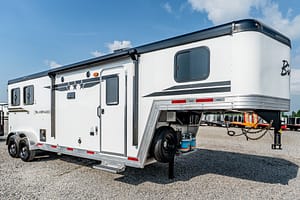 Image 0 for SKU 46394 – Leonard Truck and Trailer, Inc White fifth-wheel RV trailer with Silverado branding, side view on a gravel lot.