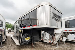 Image 0 for SKU 46488 – Leonard Truck and Trailer, Inc Gooseneck horse trailer labeled Logan Coach parked in a gravel lot with other trailers.