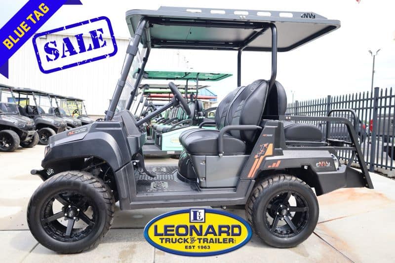 Side view of a black two-row golf cart for sale at Leonard Truck & Trailer, with a blue SALE tag visible.